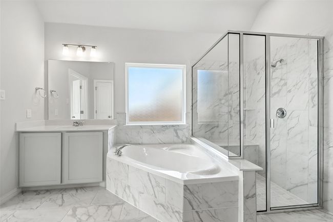 Bathroom featuring a marble finish shower, a garden tub, marble finish flooring, and vanity | Image 20