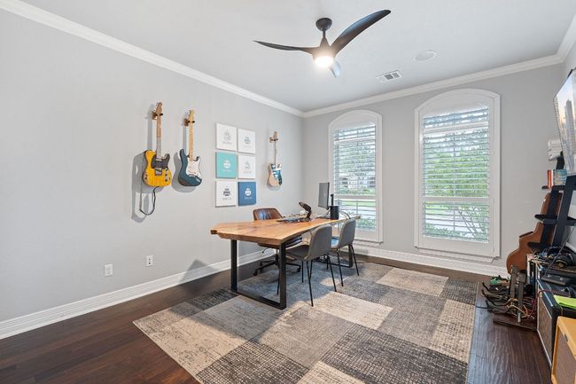 Office with wood finished floors, baseboards, crown molding, and a ceiling fan | Image 13