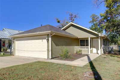 View of front facade featuring a garage, a front yard, and a porch | Image 1