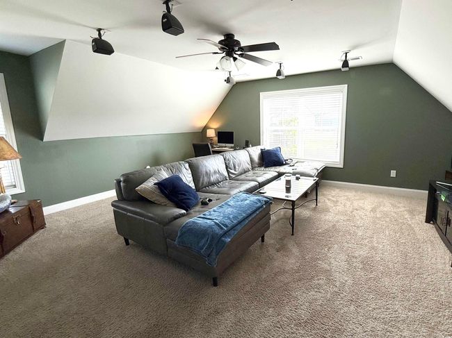 Living room featuring vaulted ceiling, healthy amount of natural light, carpet flooring, and a ceiling fan | Image 16