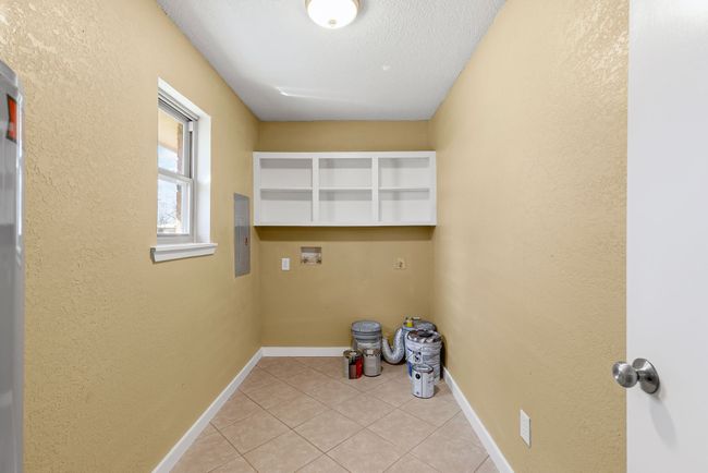 Clothes washing area featuring laundry area, light tile patterned floors, baseboards, a textured wall, and hookup for a washing machine | Image 14