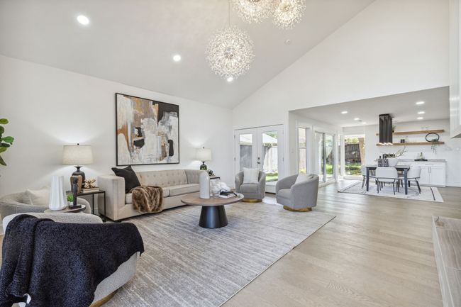 Living room with recessed lighting, light wood-style floors, an inviting chandelier, and high vaulted ceiling | Image 4