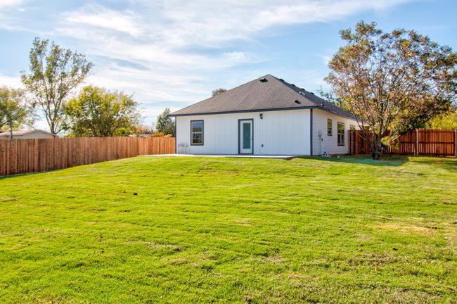 Rear view of property with a fenced backyard and roof with shingles | Image 21