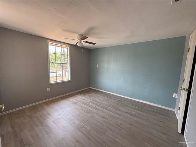 Unfurnished room featuring a ceiling fan, dark wood-style floors, and baseboards | Image 5