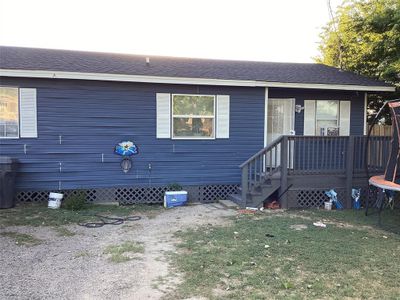 View of front facade featuring a front yard and a wooden deck | Image 2