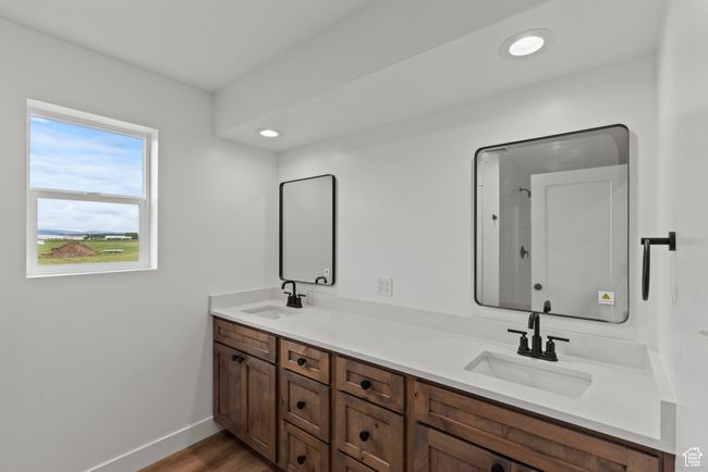 Bathroom featuring double vanity, baseboards, wood finished floors, and recessed lighting | Image 12