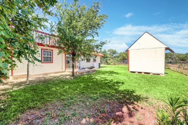 View of yard with a storage shed, an outbuilding, fence, and central AC unit | Image 19