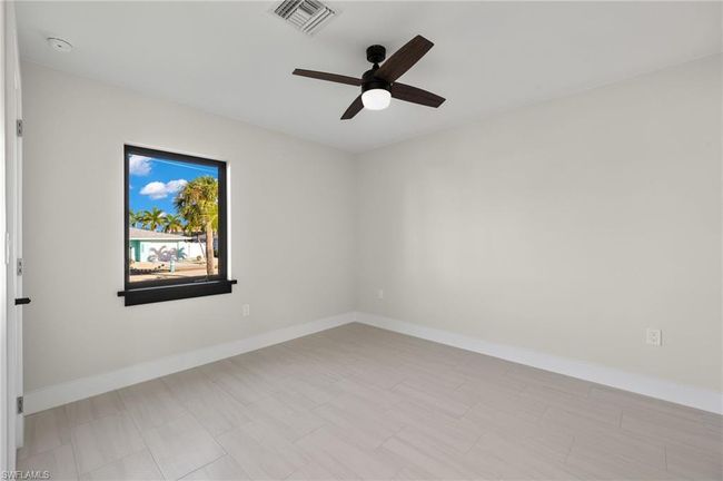 guest bedroom room with light tile patterned floors and ceiling fan | Image 29