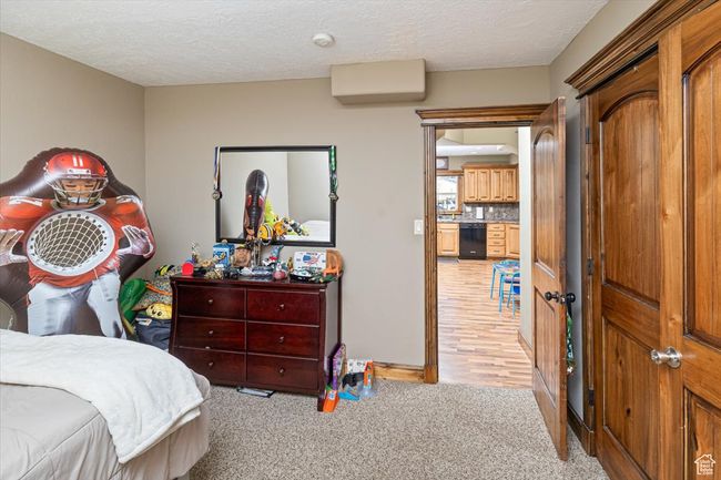 Bedroom featuring light colored carpet and a textured ceiling | Image 23