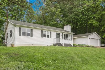 View of front of property with a front yard, a garage, and an outdoor structure | Image 2