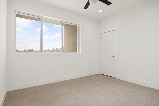 Guest room with light colored carpet, a ceiling fan, and recessed lighting | Image 15