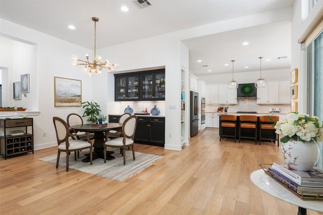 Dining space featuring light wood-style flooring, a chandelier, recessed lighting, and easy access from multiple areas. | Image 7