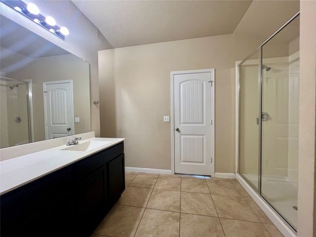 Primary bathroom with vanity, a shower stall, tile patterned flooring, and baseboards | Image 15