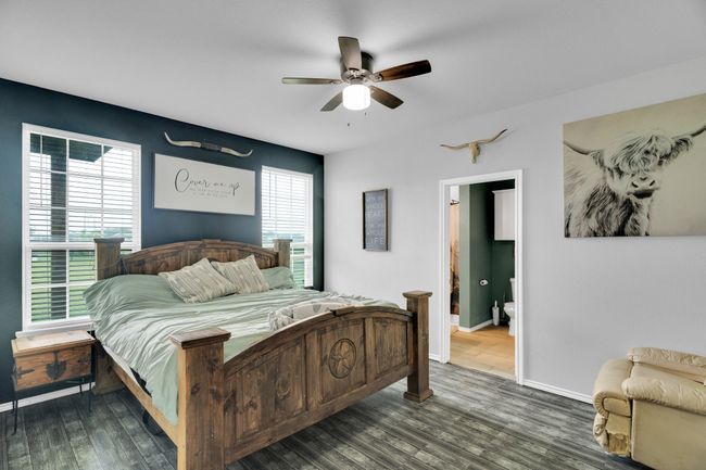 Bedroom with dark wood finished floors, baseboards, ceiling fan, and connected bathroom | Image 17