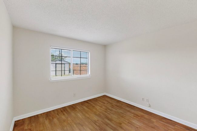 Bedroom with wood finished floors and a textured ceiling | Image 26