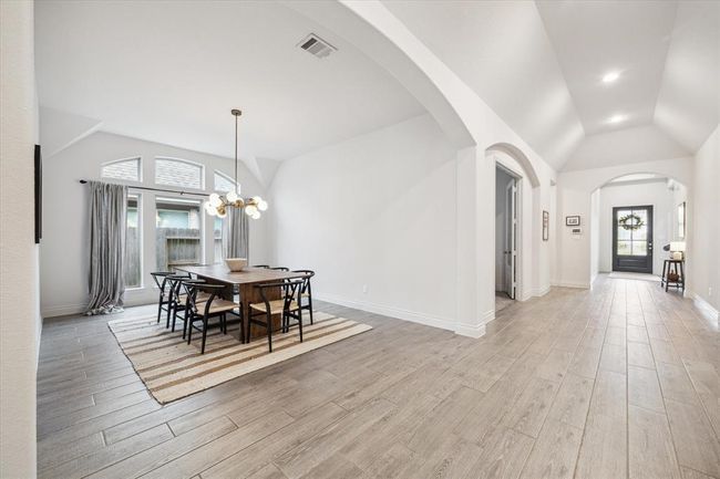 The spacious, separate dining area offers ample room for a large table, perfect for hosting memorable dinners and entertaining numerous guests. The elegance of this space is highlighted by the natural light streaming through the windows, creating a warm and inviting atmosphere. | Image 7