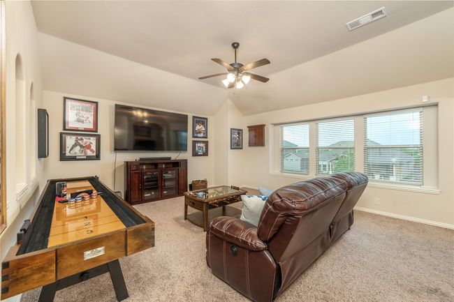 Living area featuring a ceiling fan, carpet floors, lofted ceiling, and baseboards | Image 23