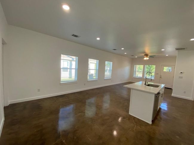 Kitchen featuring a sink, baseboards, an island with sink, recessed lighting, and a ceiling fan | Image 4