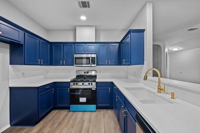 Kitchen with stainless steel appliances and blue cabinets, new hardware, countertops, paint | Image 4