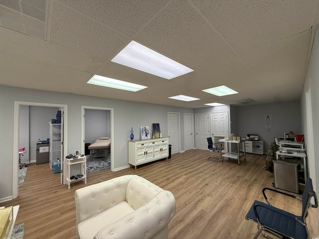 Living room with light wood-style flooring and baseboards | Image 11