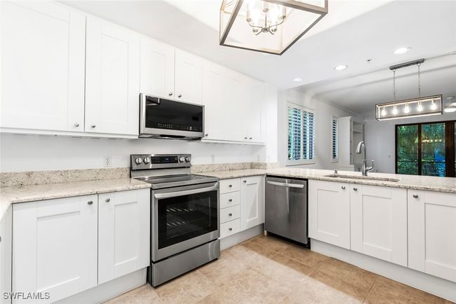Kitchen with white cabinets, stainless steel appliances, hanging light fixtures, and sink | Image 33
