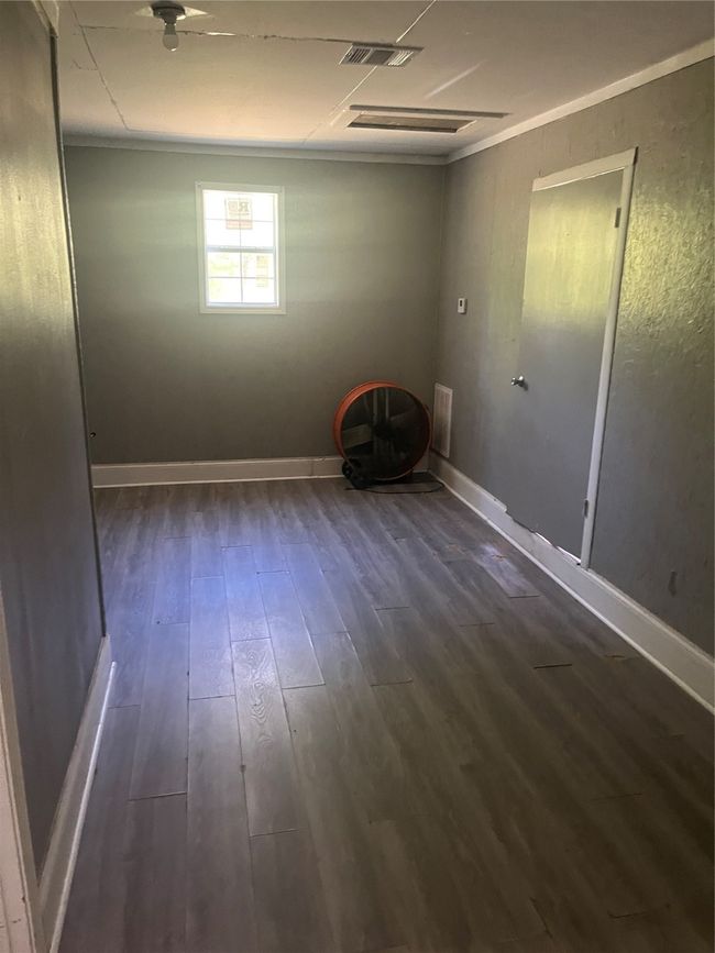 Unfurnished room with baseboards, dark wood finished floors, and visible vents | Image 19