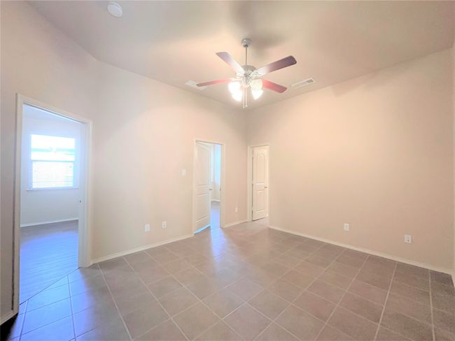 Tiled empty room featuring a ceiling fan and a smoke detector | Image 8
