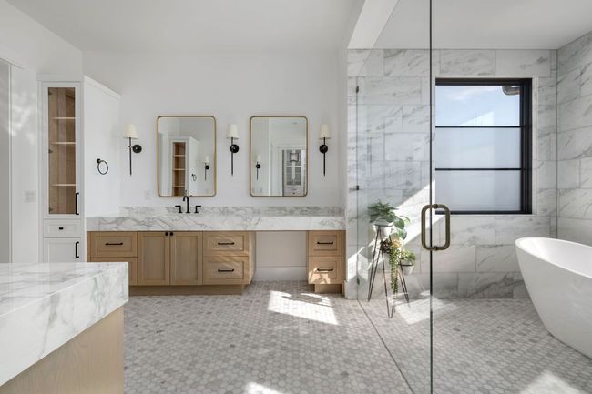 Bathroom featuring a freestanding tub, vanity, tile walls, and a shower stall | Image 18