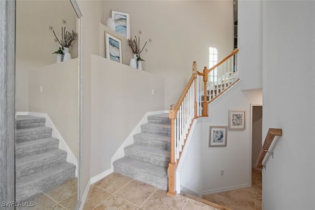 Stairway with tile patterned flooring, a towering ceiling, and baseboards | Image 37