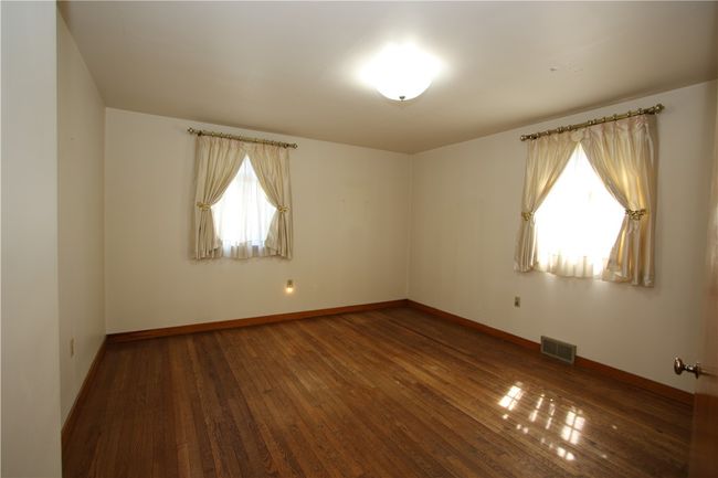 Spacious 14x13 Master Bedroom w/ 2 Windows allowing the Natural Light to Flow in Nicely, Gorgeous Original Hardwood Floors & Plaster Walls | Image 5