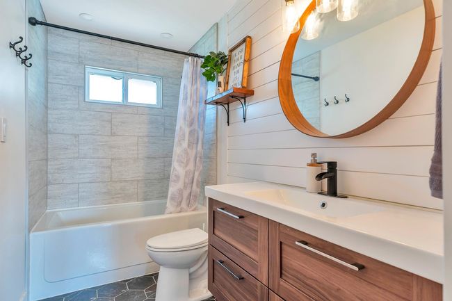 Full bathroom with toilet, tile patterned floors, shower / tub combo, and vanity | Image 27