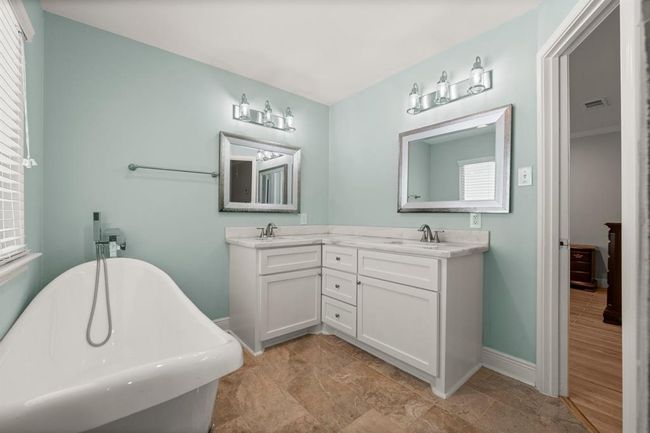 Bathroom featuring a modern design with a freestanding clawfoot bathtub, and a dual-sink vanity. | Image 24