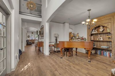 Dining space with light wood-type flooring, crown molding, and a chandelier | Image 2