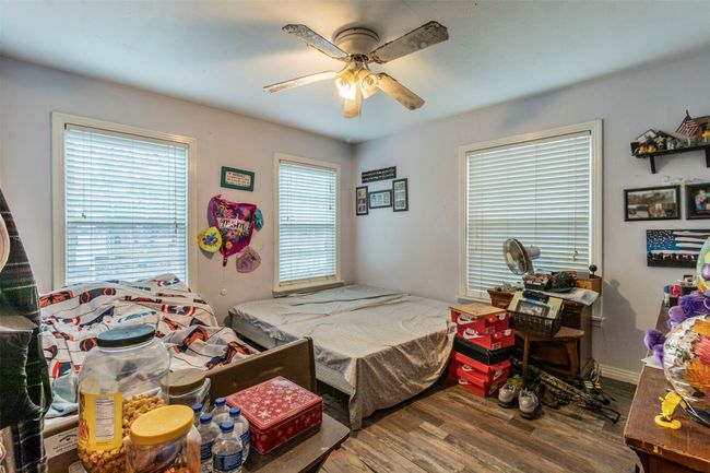 Bedroom with multiple windows, ceiling fan, and wood finished floors | Image 12
