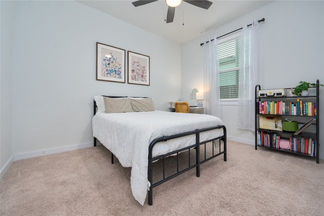 Bedroom featuring light colored carpet and ceiling fan | Image 12