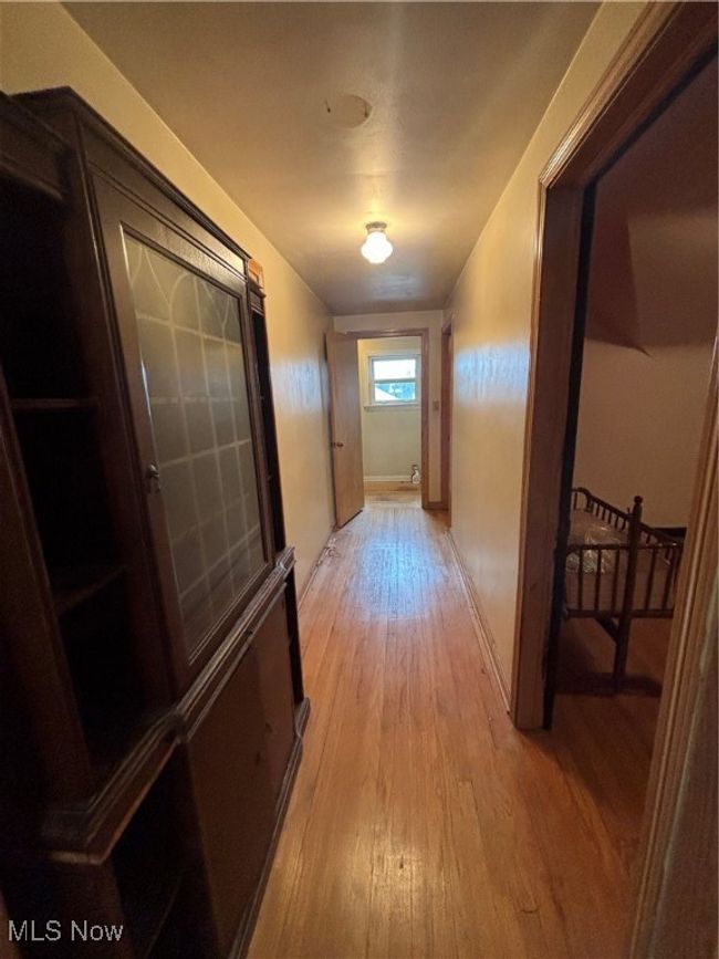 Corridor with light wood-style flooring and baseboards | Image 8
