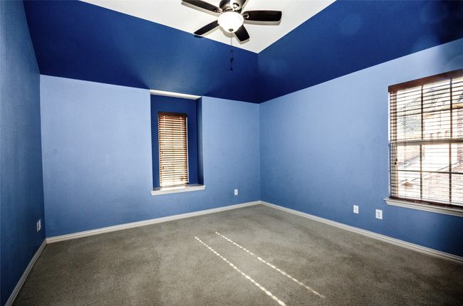 Spare room featuring a ceiling fan, lofted ceiling, carpet flooring, and baseboards | Image 18