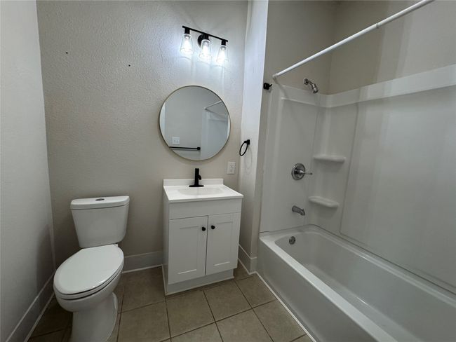 Bathroom featuring baseboards, toilet, shower / bath combination, vanity, and tile patterned flooring | Image 7