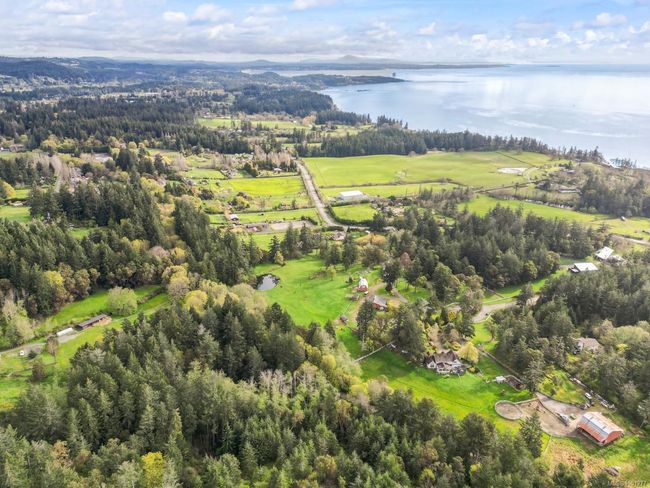 Aerial view of property and surrounding area with a large body of water and a heavily wooded area | Image 51