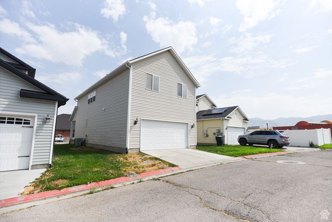 View of side of property featuring cooling unit, a garage, and a mountain view | Image 33