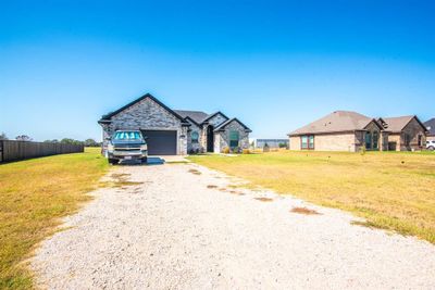 View of front facade with a garage and a front lawn | Image 1