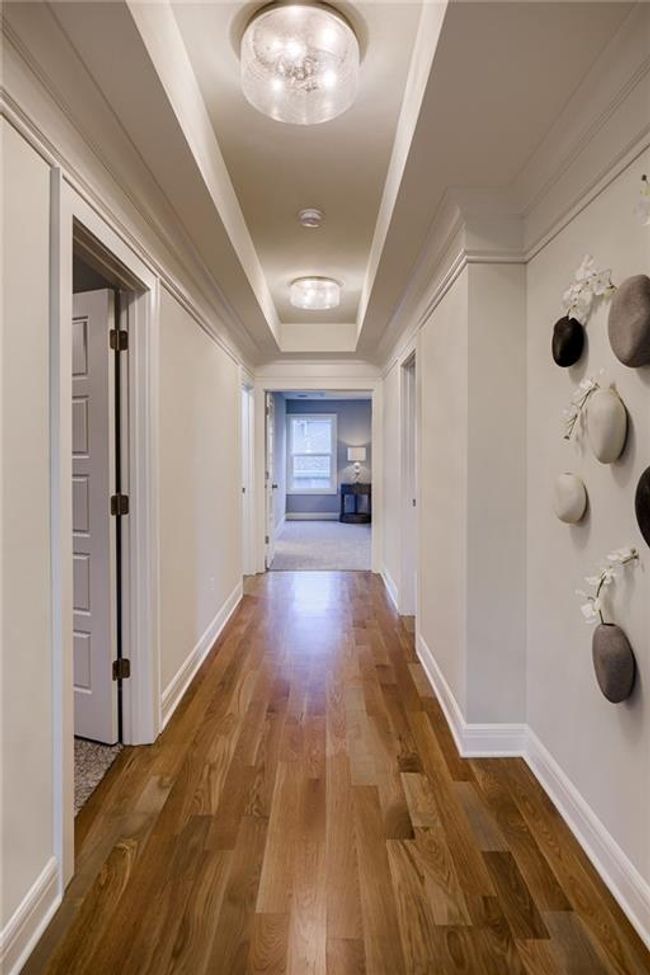 Corridor featuring hardwood / wood-style floors and a raised ceiling | Image 26
