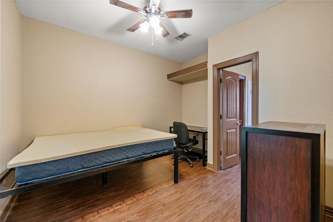 Bedroom with light wood finished floors and a ceiling fan | Image 11