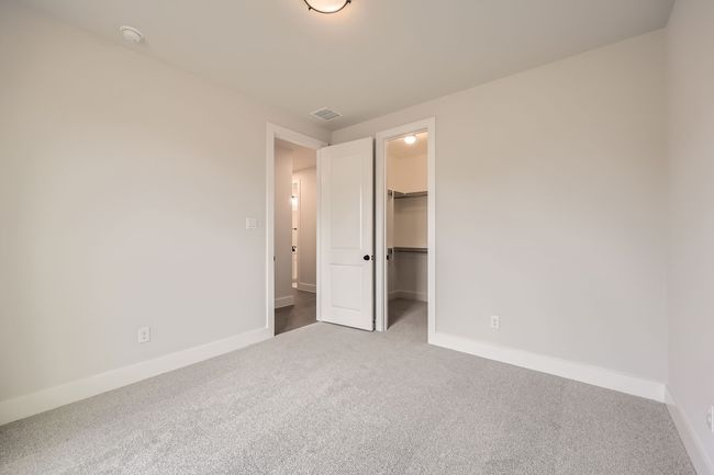 Unfurnished bedroom featuring a closet, carpet flooring, visible vents, baseboards, and a spacious closet | Image 22