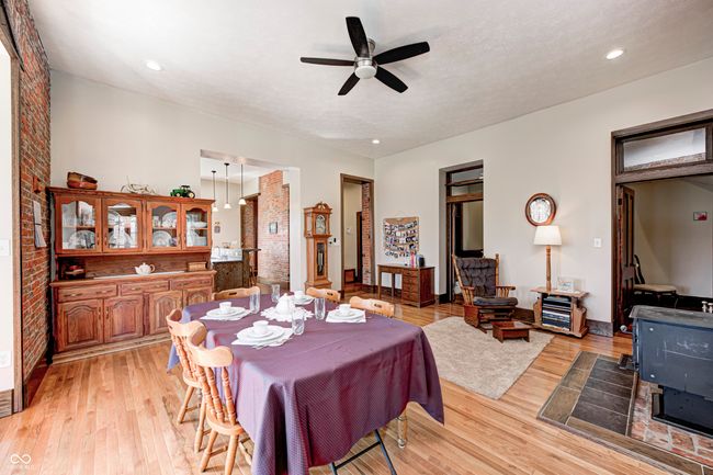 dining space featuring brick wall, ceiling fan, a textured ceiling, recessed lighting, and light wood-style flooring | Image 14