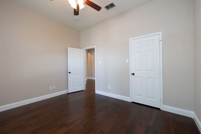 Unfurnished bedroom featuring dark wood-style floors and ceiling fan | Image 23