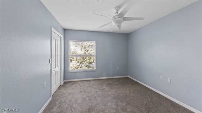 Empty room with carpet flooring, baseboards, and a ceiling fan | Image 10