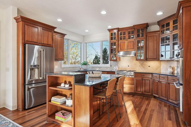 Kitchen is a chef's dream and features double ovens, gas range, microwave (tucked in the center island), dishwasher and refrigerator. | Image 22