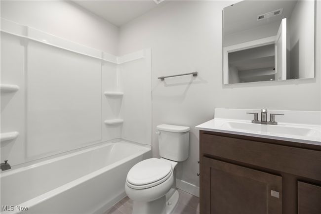 Full bathroom featuring shower combination, vanity, visible vents, and toilet | Image 9