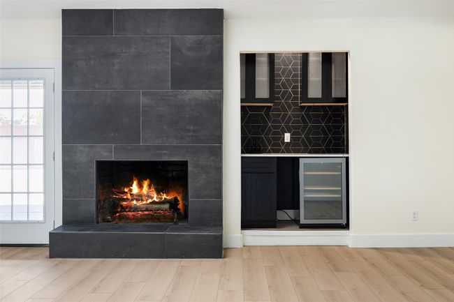 Detailed view of beverage cooler, wood finished floors, and a fireplace | Image 24